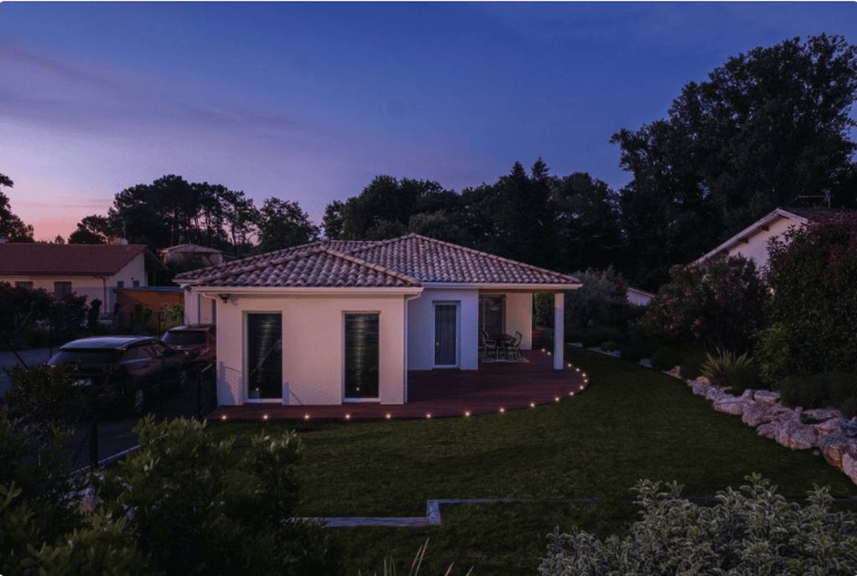La maison et sa pelouse au crépuscule, sous un ciel violet
