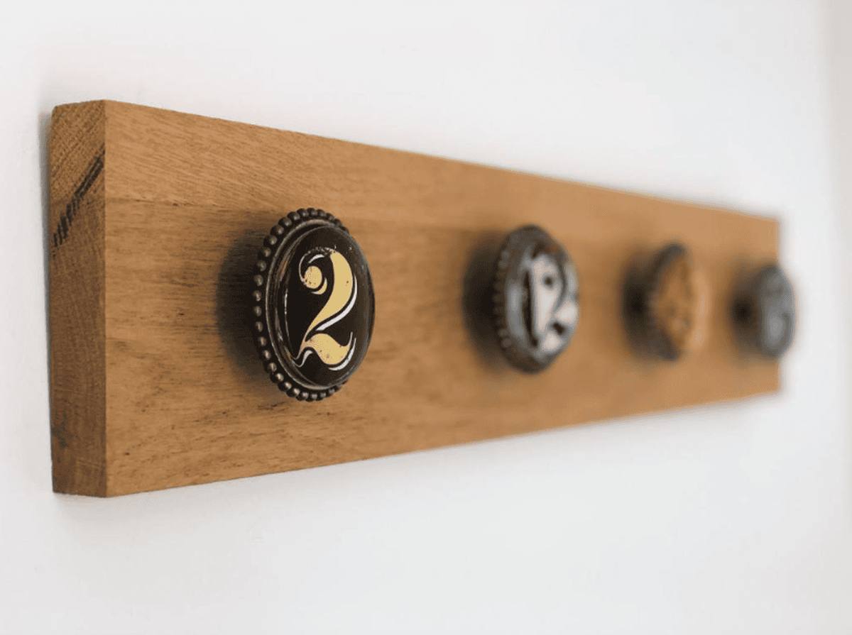 Des patères en bois aux boutons numérotés, fixées au mur blanc